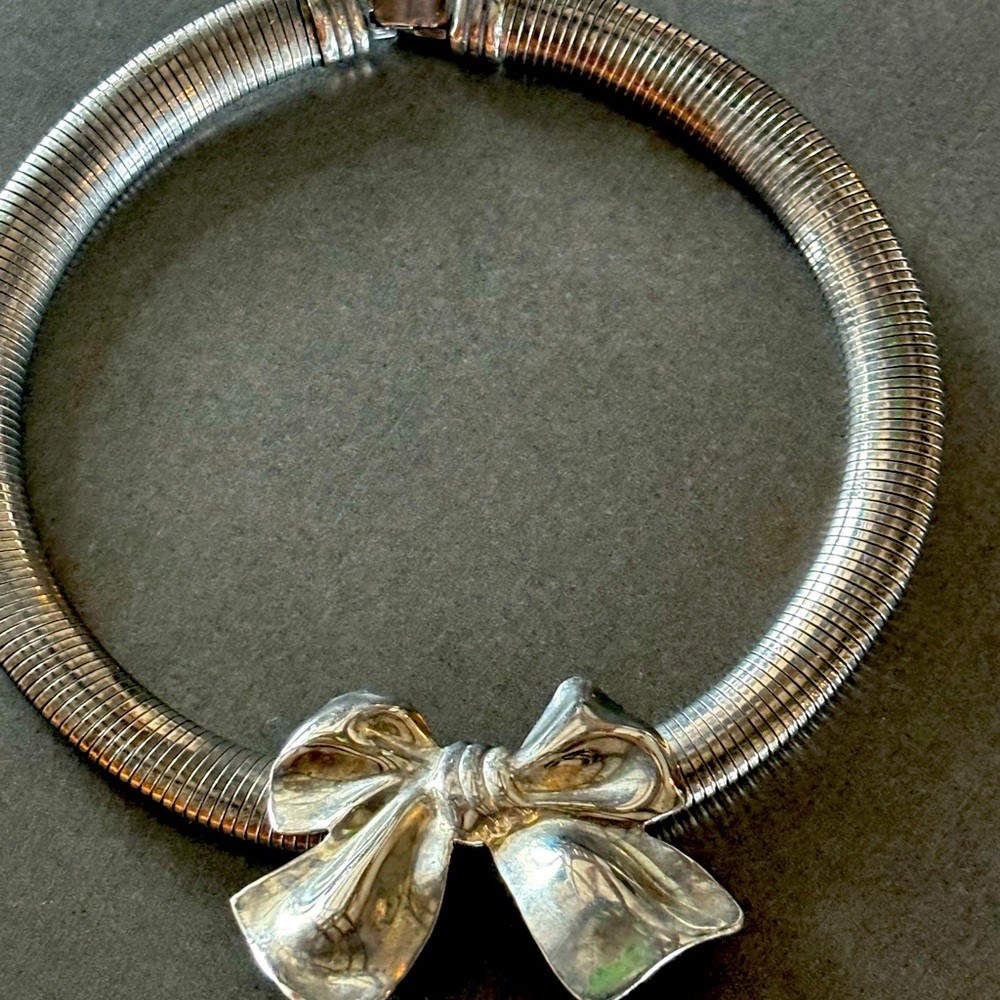 Heavy silver snake chain choker with shiny silver bow.